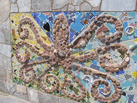 Cool octopus art made of tile, stones and shells.