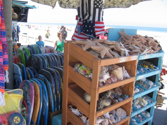 Shells and boogie boards line the boardwalk for passing tourists.