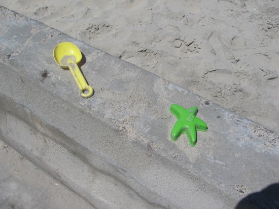Colorful beach toys left on the concrete sea wall.