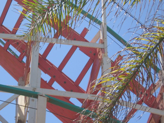 Palm fronds, colorful track and clear blue sky.