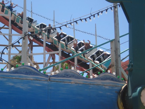 Riders whiz by as the cars rattle on wooden rails.