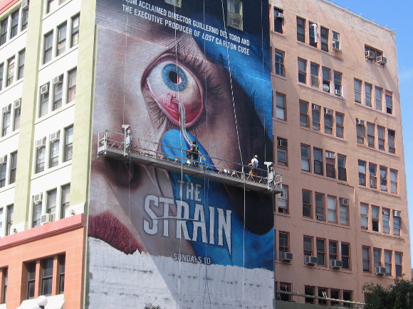 Worker paints worm dangling from a huge bulging eyeball!