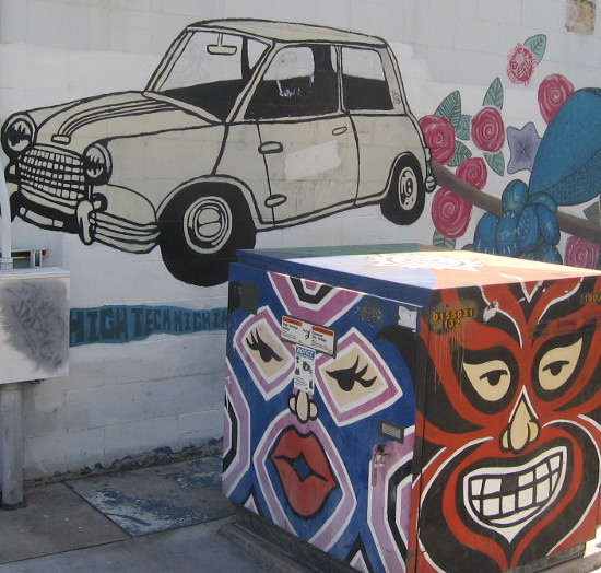 Exotic faces, car and flowers along sidewalk in San Diego.