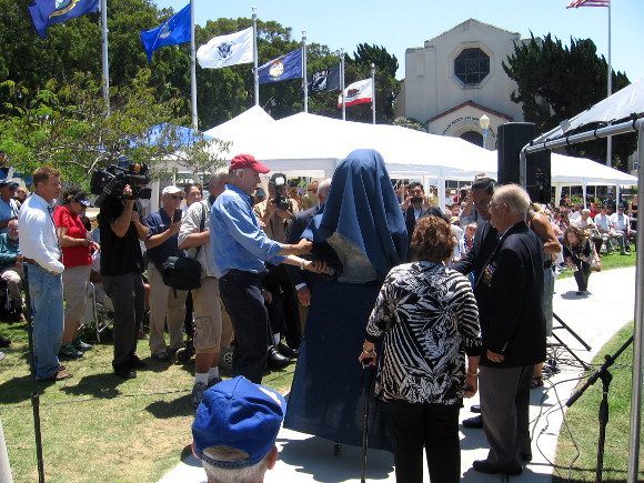 A bust to be set near B-24 Liberator is unveiled by the artist and others.