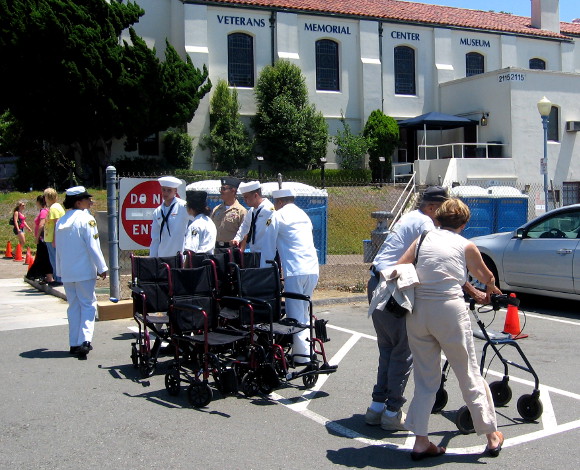 Sailors help the aging American heroes back to their cars.