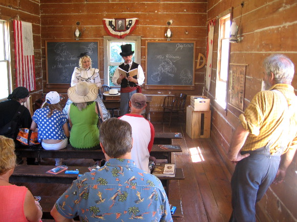 Actors read poetry from Alice in Wonderland in one room schoolhouse.