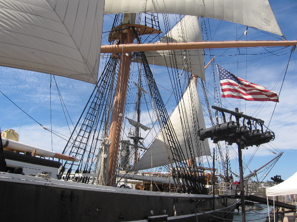 American flag flutters in the breeze at stern of the historic old ship.