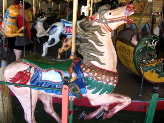 A brightly painted carved wooden horse awaits a passenger.