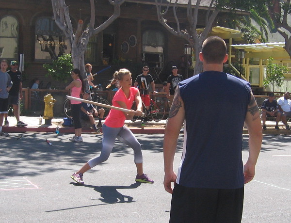 Lady swings and crushes the ball a long distance down Columbia Street!