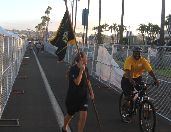 Navy sailors run along Harbor Drive before the Labor Day weekend event begins.