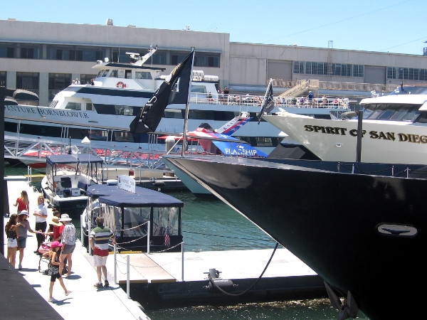 People linger on dock near water taxis.