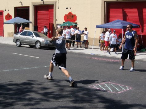 Stickball action in front of the San Diego Firehouse Museum.