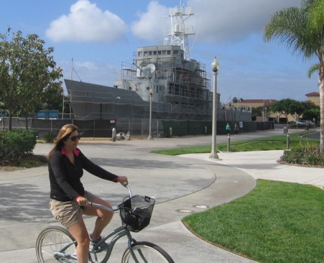 A bicyclist passing the USS Recruit heads into Liberty Station.