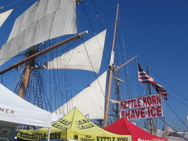 The sails of the historic Star of India rise beyond a kettle corn sign!