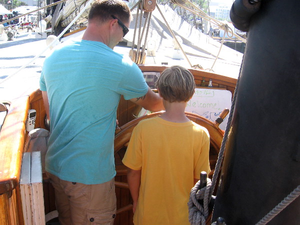 Two generations, side by side, man the helm topside.