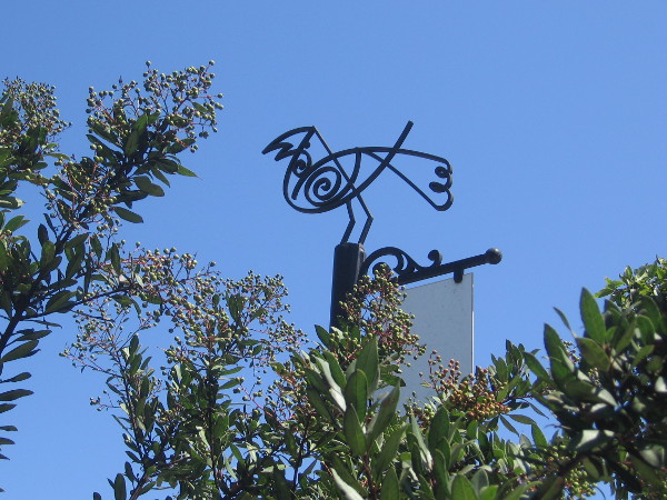 Metal artwork resembles a bird perched atop trees in the downtown community.