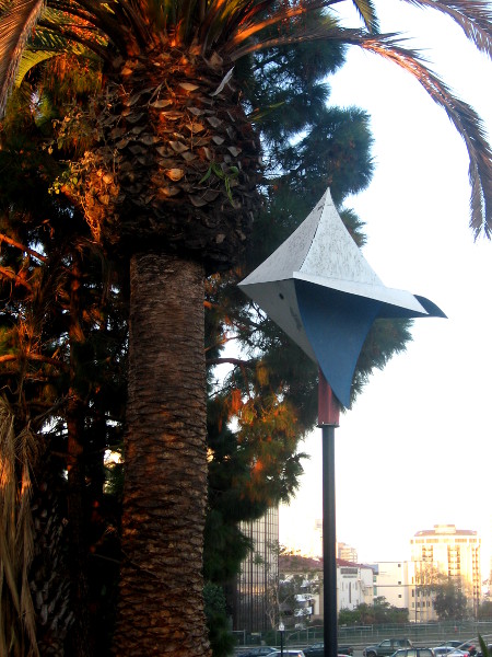 Stylish birdhouse, palm tree and downtown buildings.