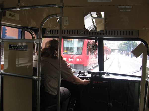 As we ride down C Street, a modern red trolley is seen on the opposite track.