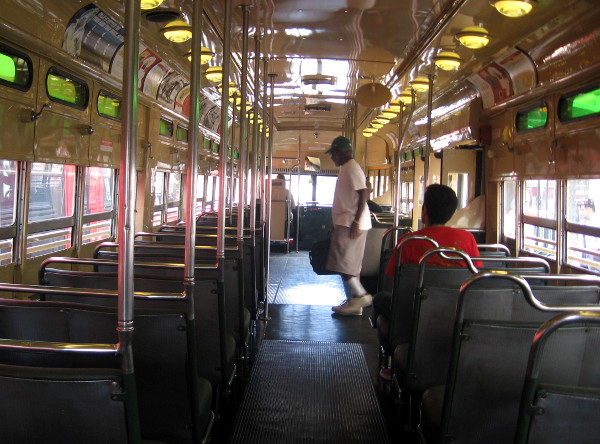 Another passenger steps onto the restored trolley at the Fifth Avenue station.