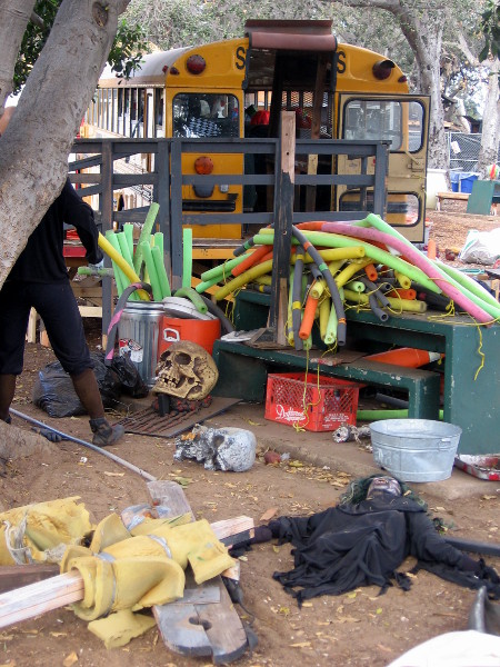 Props on ground behind a school bus filled with Halloween frights.