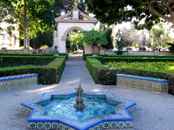 Moorish tiles on a fountain, colorful benches and an archway.