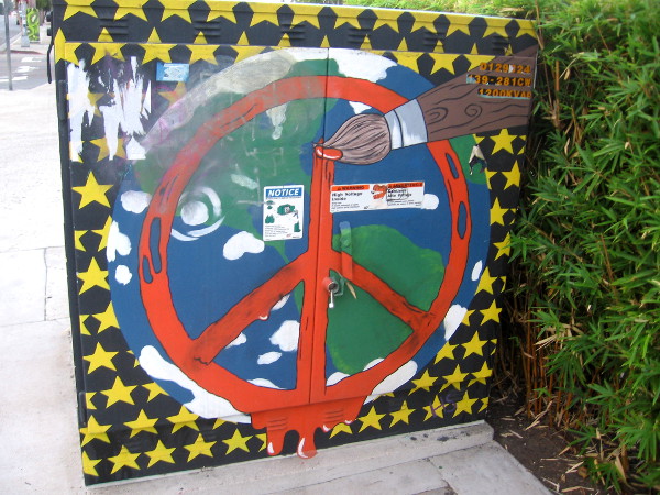 Peace symbol, planet Earth, paintbrush and stars on side of Hillcrest transformer.