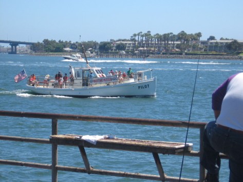 The Pilot with sightseeing tourists cruises past a pier on San Diego Bay.