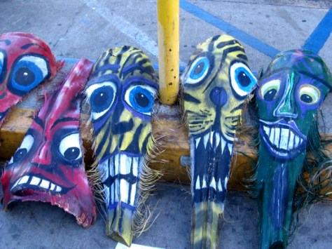 Whiskery, crazy, colorful faces painted on palm fronds.