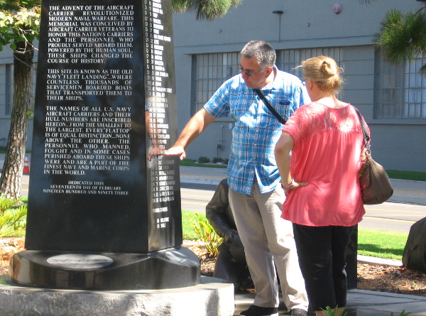 Man points out a recent fleet carrier name on the Aircraft Carrier Memorial.