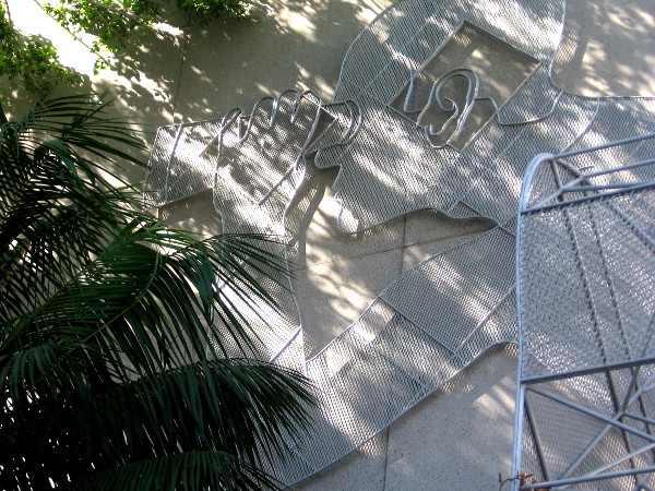 Man with binoculars peers into dark alley between convention center and Marriott.