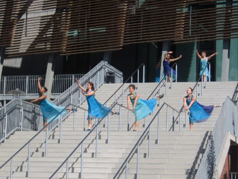 Graceful dancers descend the high stairs in a grand entrance!