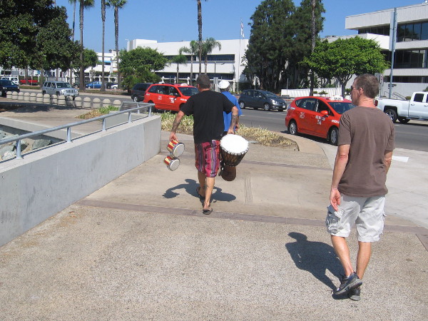 Boater walks along the Embarcadero with some drums.