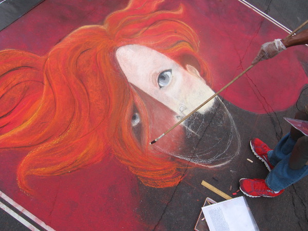 Lisa Pierre-Davis uses a long stick with chalk tip to outline her work in progress.