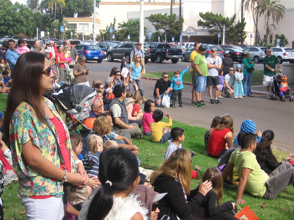 A crowd gathers to watch a pumpkin descend and explode into a million pieces!