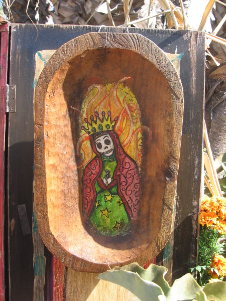 Small image in crude wooden frame in a larger altar.
