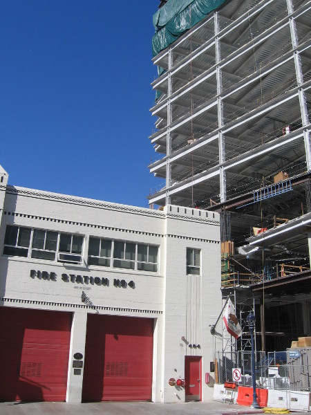 Stately little Fire Station No. 4 beside new modern skyscraper.