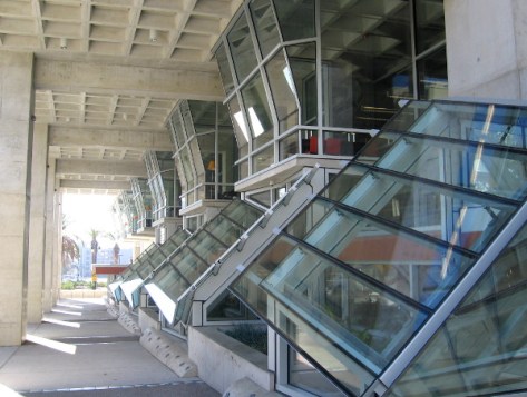 Angled glass windows along passage on Park Boulevard side of complex building.