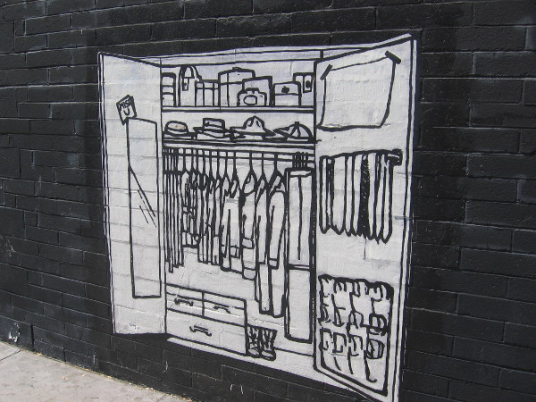 Closet full of clothes opens onto a city sidewalk.