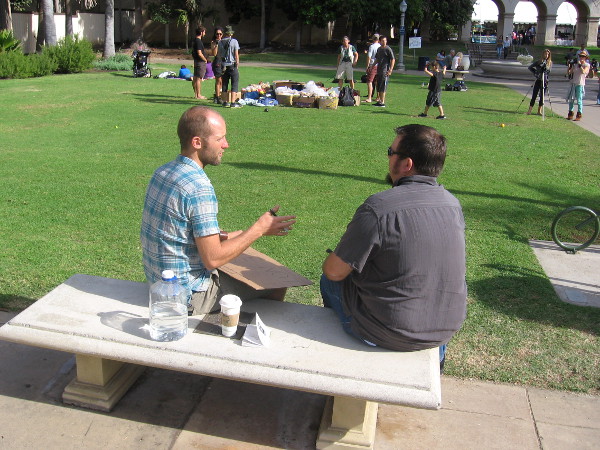 Rob Greenfield explains his goals on a bench, with Casa del Prado arches in the background.