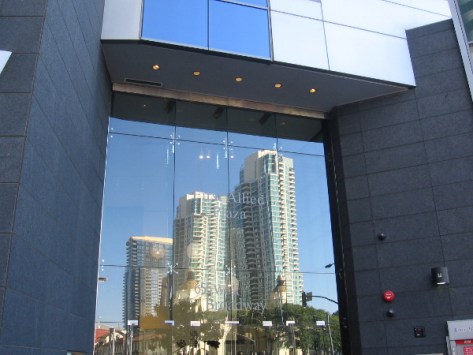 Three tall buildings reflect from downtown San Diego window.