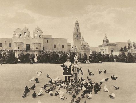 Kids feed pigeons on the central Plaza de Panama. The Indian Arts Building with mission bells on left was renamed House of Charm and reconstructed in 1996. It now contains the Mingei Museum.