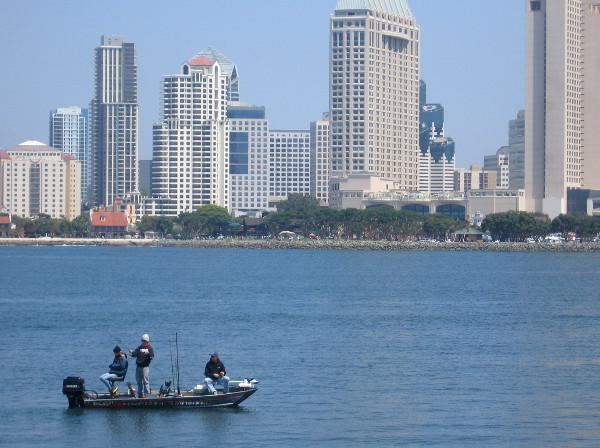 Fishermen enjoy a day on San Diego Bay with downtown skyline in background.