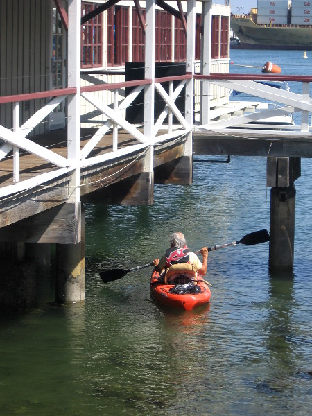 Kayaker checks out the water underneath Joe's Crab Shack.