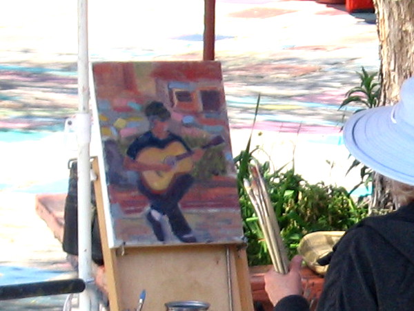 A painted guitarist seems to emerge from sunny San Diego dappled brightness.