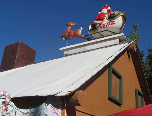 Santa Claus has landed with his little reindeer on a rooftop!