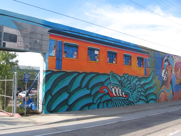 San Diego Trolley travels through a scene similar to those found in nearby Chicano Park.