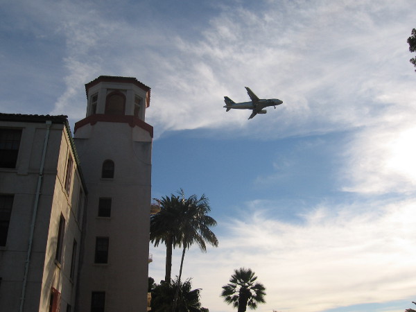 Plane approaching Lindbergh Field flies above Balboa Park Administration Building.
