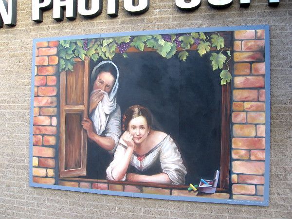 Two people gaze from painted mural window in Little Italy.