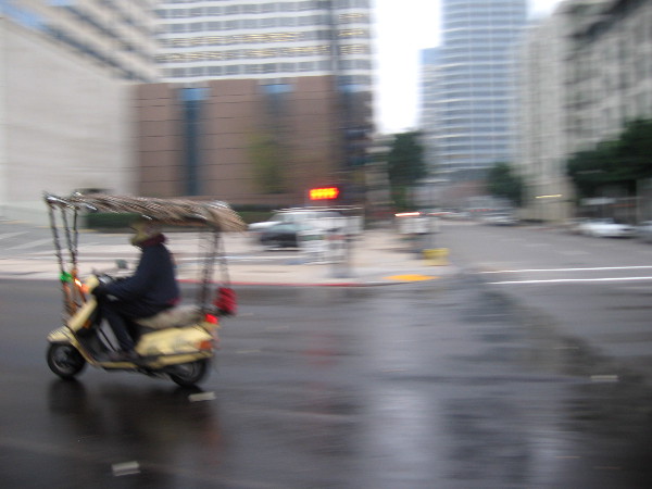 Scooter with fringed canopy zooms past as I swing my camera to capture a sudden morning photo.