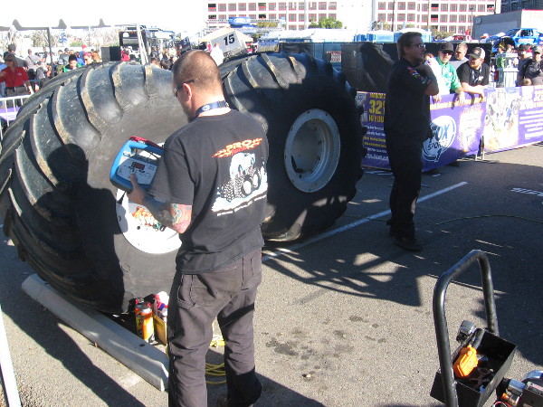 Mechanic guy near a couple of gigantic spare tires.